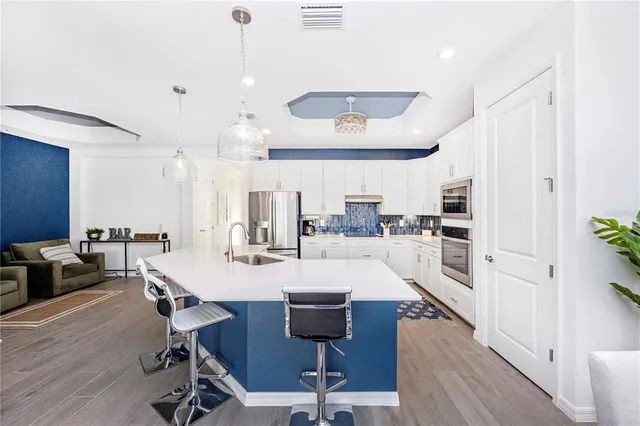 a living room with stainless steel appliances kitchen island granite countertop furniture and a dining table