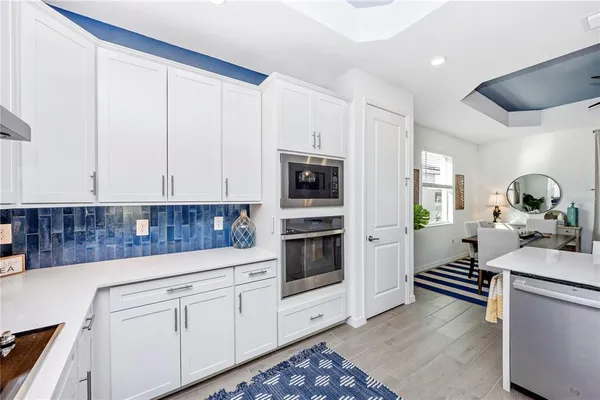 a living room with furniture kitchen view and a chandelier