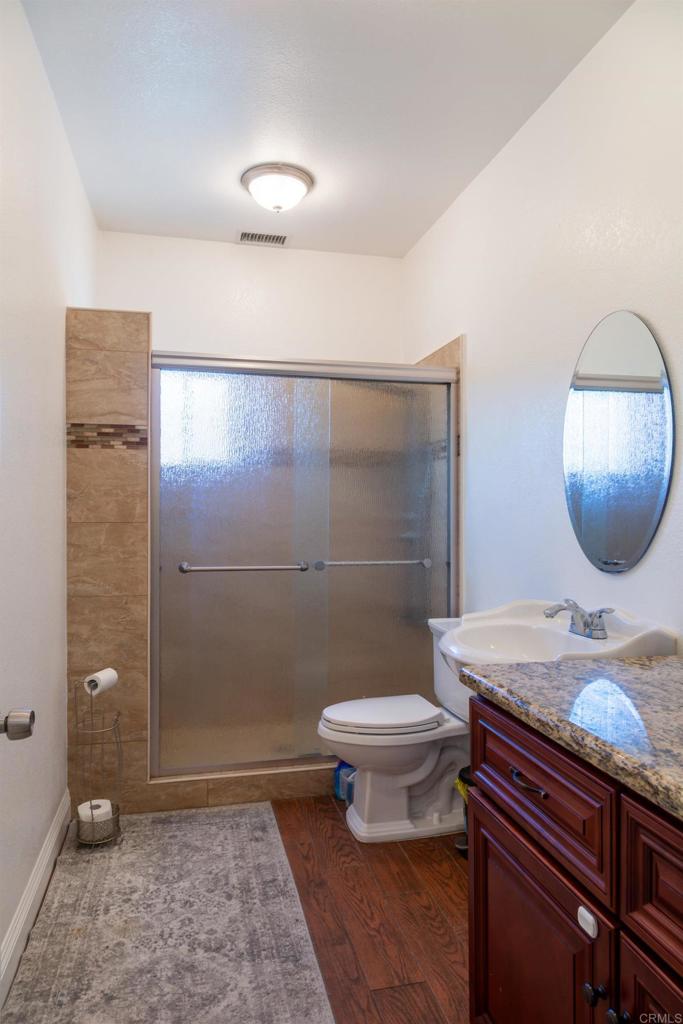 1657 Coronado Avenue Spring Valley, CA 91977 - Photo 29 of 46 a bathroom with a granite countertop toilet a sink and mirror
