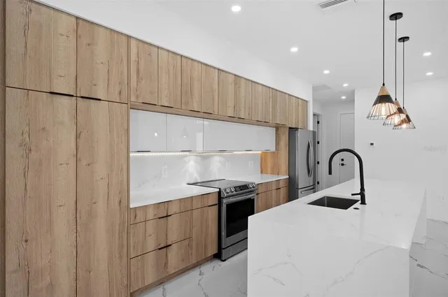 a kitchen with stainless steel appliances a refrigerator sink and cabinets