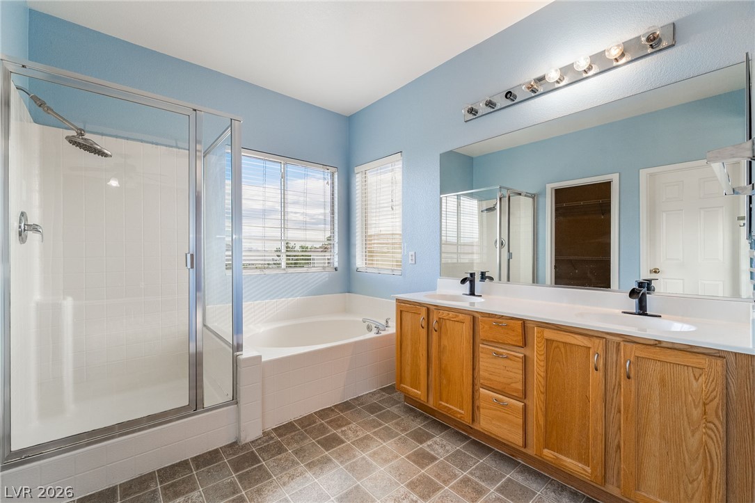 224 Positive Point Street Henderson, NV 89012 - Photo 26 of 44 Natural light from multiple windows highlights a double vanity, soaking tub, and walk-in shower.