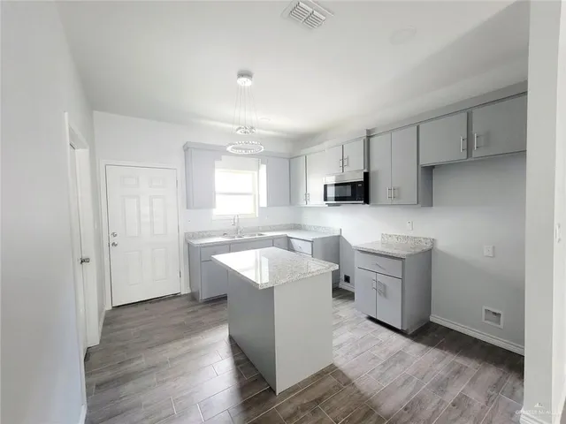 a kitchen with a sink cabinets and wooden floor