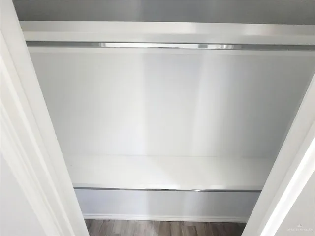 a view of a closet with wooden floor