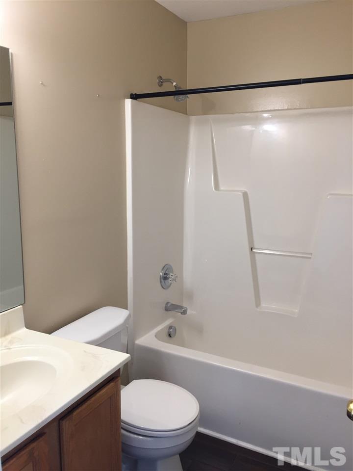 5405 Advantis Drive Raleigh, NC 27610 - Photo 13 of 16 a bathroom with a sink a toilet and a bathtub