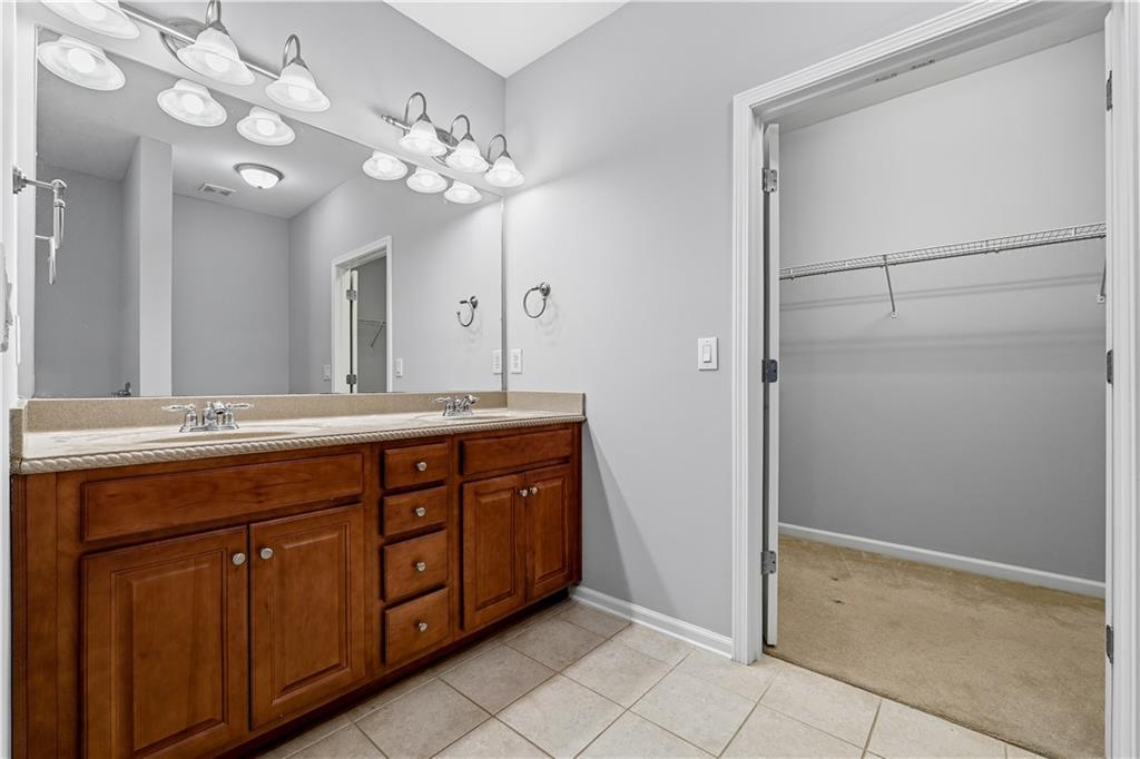 2310 Callaway Court Cumming, GA 30041 - Photo 18 of 30 a spacious bathroom with a double vanity sink and a mirror