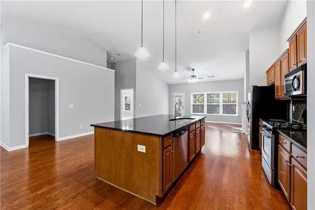 a kitchen with stainless steel appliances granite countertop a stove and a wooden floors