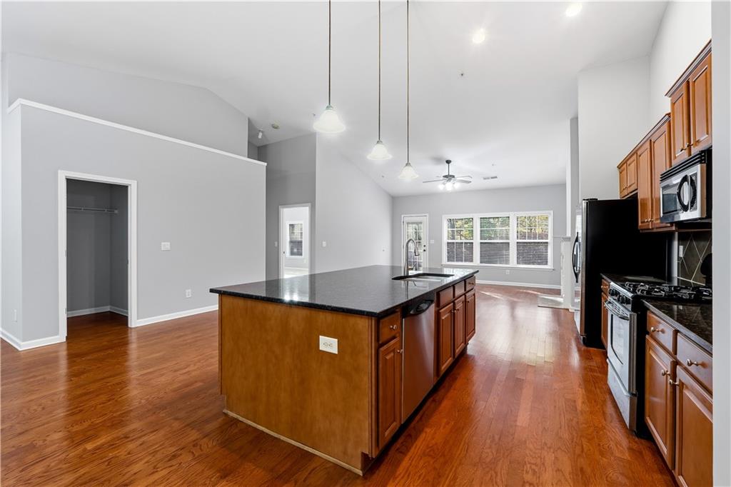 2310 Callaway Court Cumming, GA 30041 - Photo 6 of 30 a kitchen with stainless steel appliances granite countertop a stove and a wooden floors