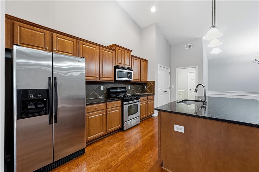 2310 Callaway Court Cumming, GA 30041 - Photo 9 of 30 a kitchen with stainless steel appliances granite countertop a refrigerator a sink and white cabinets