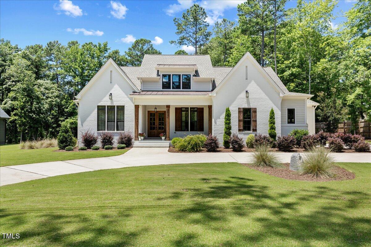 a front view of a house with porch and garden