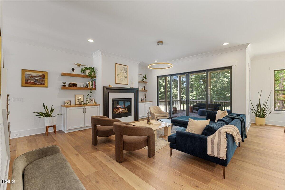 8420 Bells Lake Road Apex, NC 27539 - Photo 22 of 65 a living room with furniture large window and a fireplace