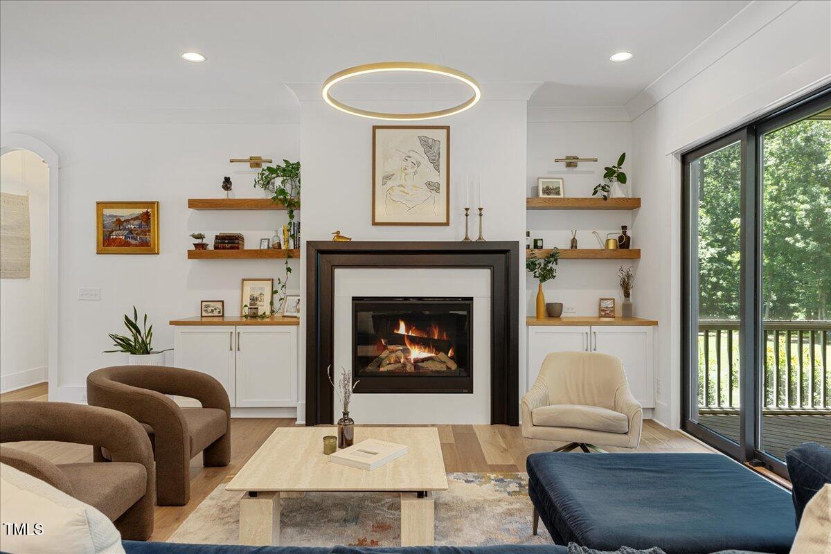 8420 Bells Lake Road Apex, NC 27539 - Photo 23 of 65 a living room with furniture a fireplace and a large window