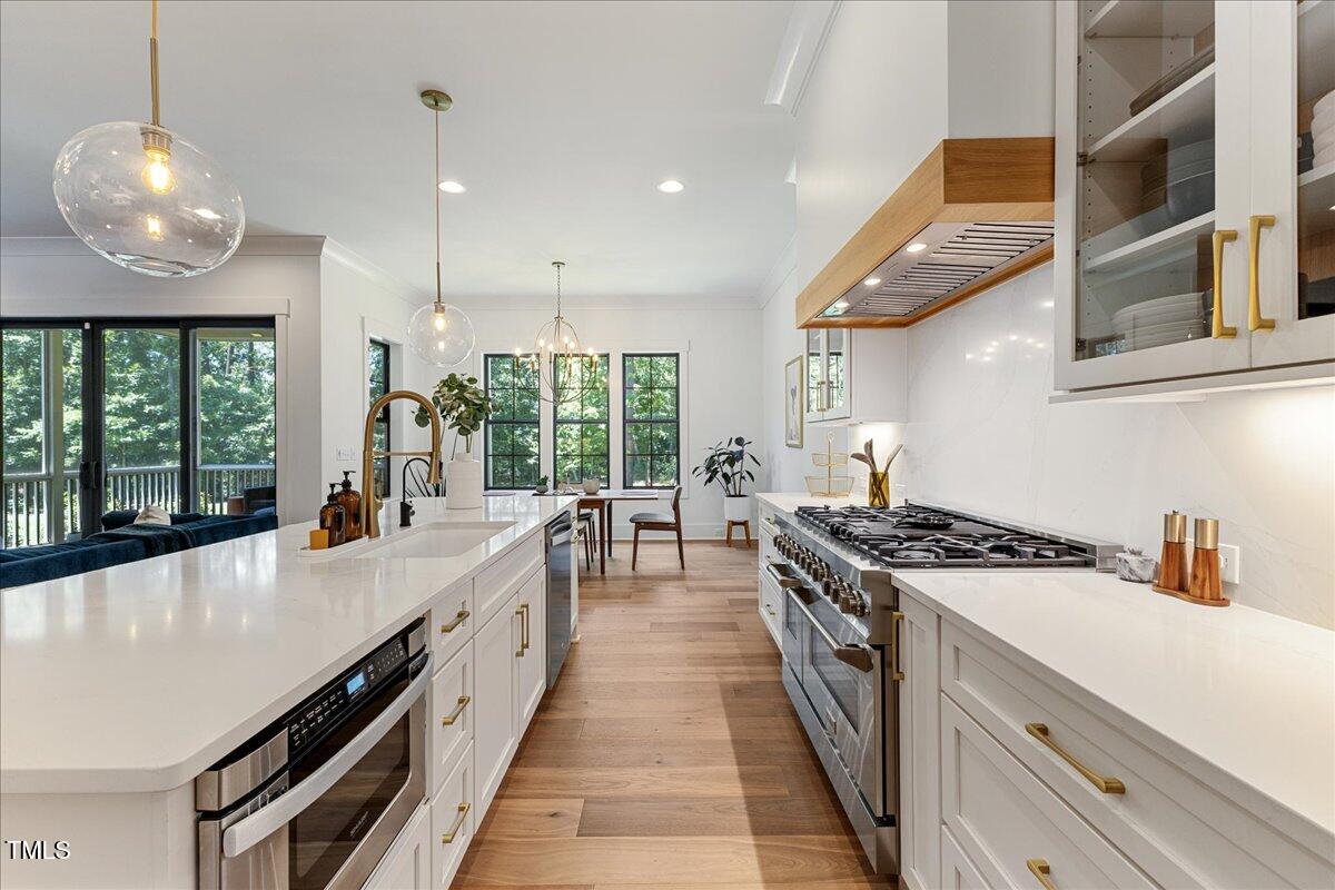 8420 Bells Lake Road Apex, NC 27539 - Photo 29 of 65 a large kitchen with stainless steel appliances granite countertop a large stove a sink and a refrigerator