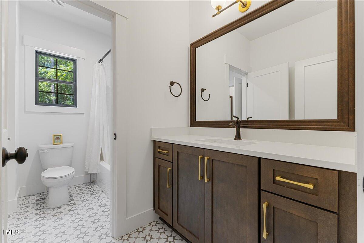 8420 Bells Lake Road Apex, NC 27539 - Photo 51 of 65 a bathroom with a sink a toilet a mirror and shower