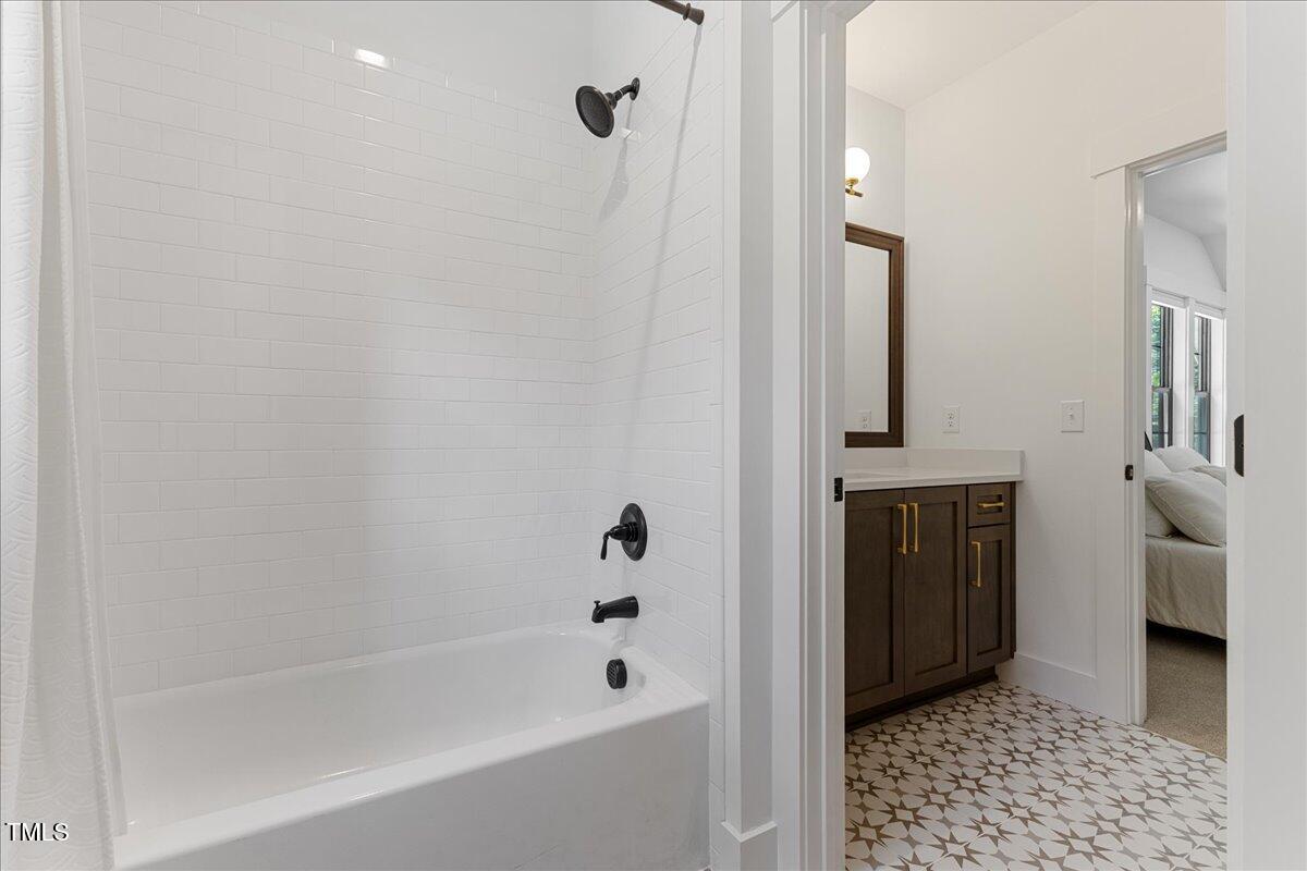 8420 Bells Lake Road Apex, NC 27539 - Photo 52 of 65 a bathroom with a bathtub and a shower