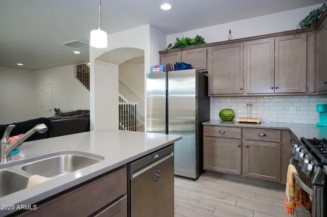 a kitchen with stainless steel appliances a sink cabinets and a refrigerator