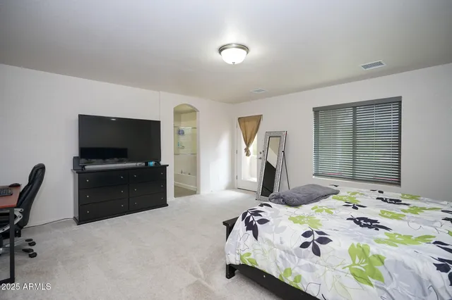 a bedroom with a bed and a flat screen tv