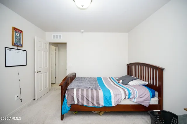 a bedroom with a bed and painting on the wall