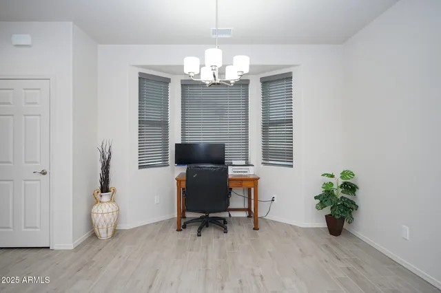 a view of a workspace with furniture and a window