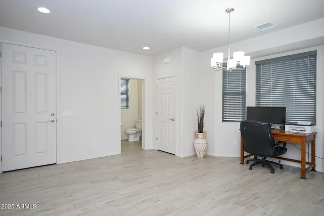 a view of a workspace with furniture and a chandelier