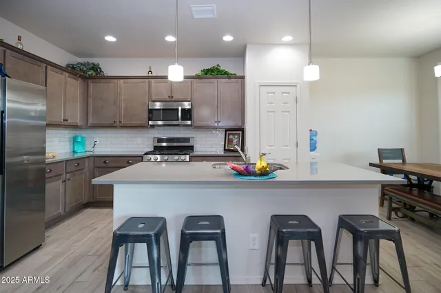a kitchen with cabinets a sink stainless steel appliances and a center island
