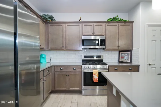 a kitchen with stainless steel appliances a stove a sink and a refrigerator