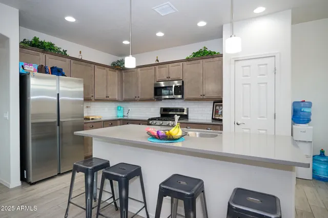 a kitchen with stainless steel appliances a refrigerator sink and wooden cabinets