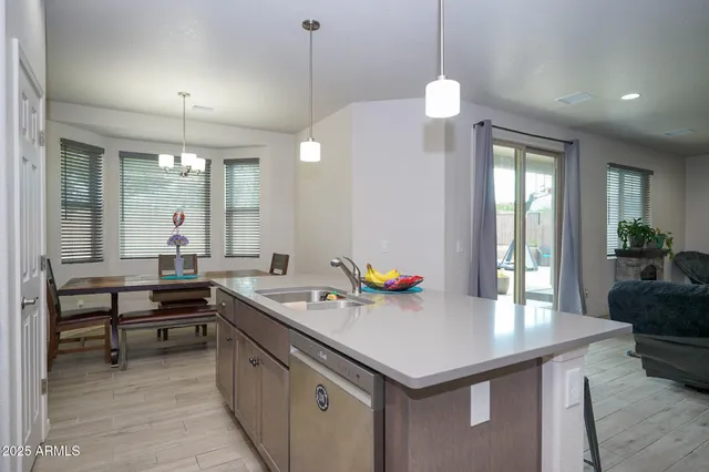 a kitchen with a stove a sink and a wooden floor