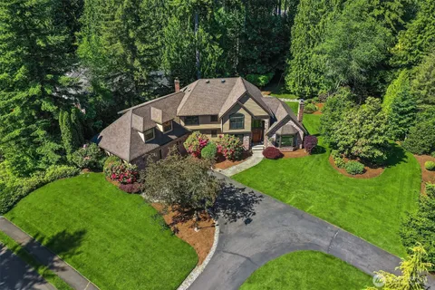 a aerial view of a house with a big yard plants and large trees