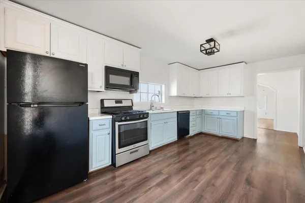 a kitchen with a refrigerator and a stove top oven