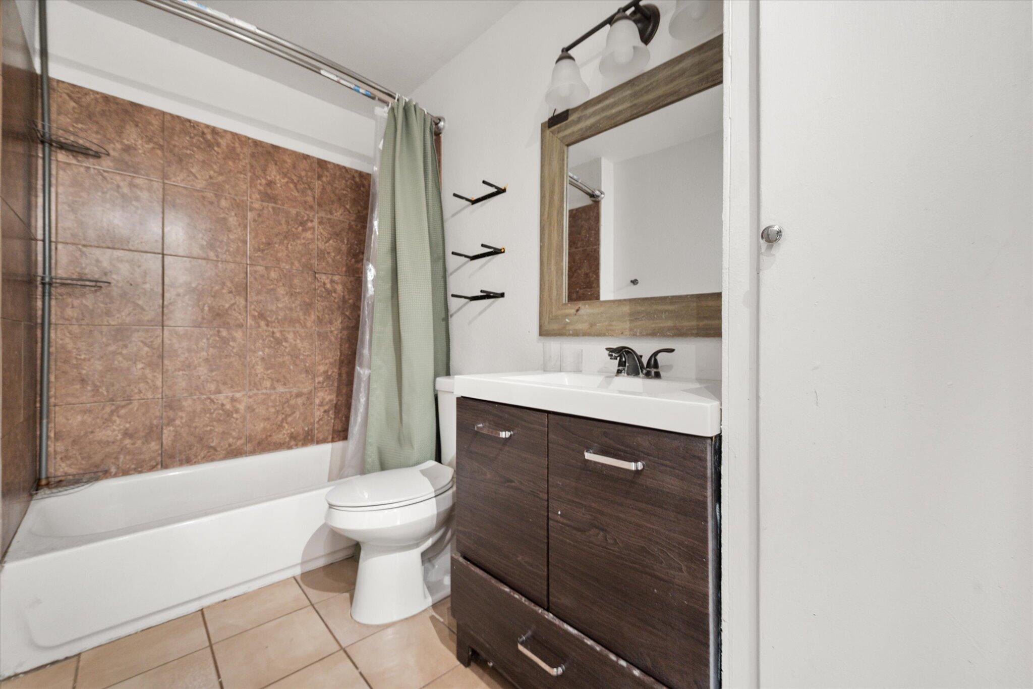 1303 28th Street Lubbock, TX 79411 - Photo 6 of 12 a bathroom with a sink a toilet and shower