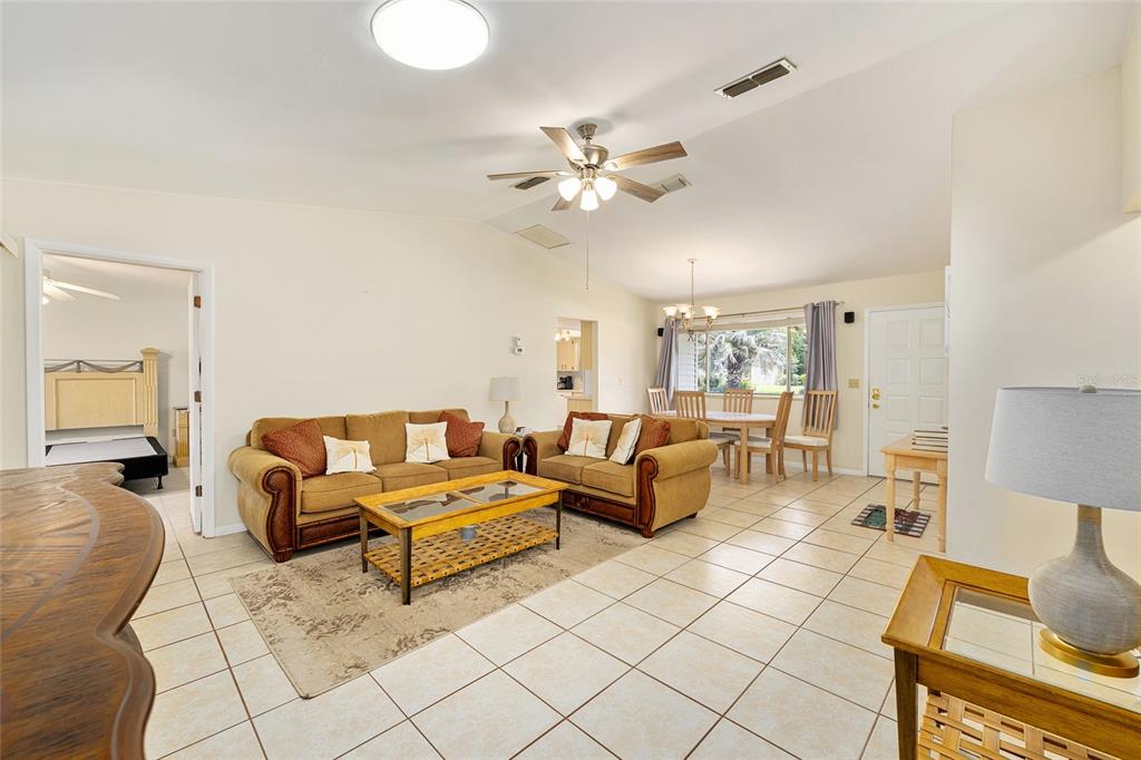 10888 Southwest 90th Court Ocala, FL 34481 - Photo 14 of 37 a living room with couches and kitchen view with wooden floor