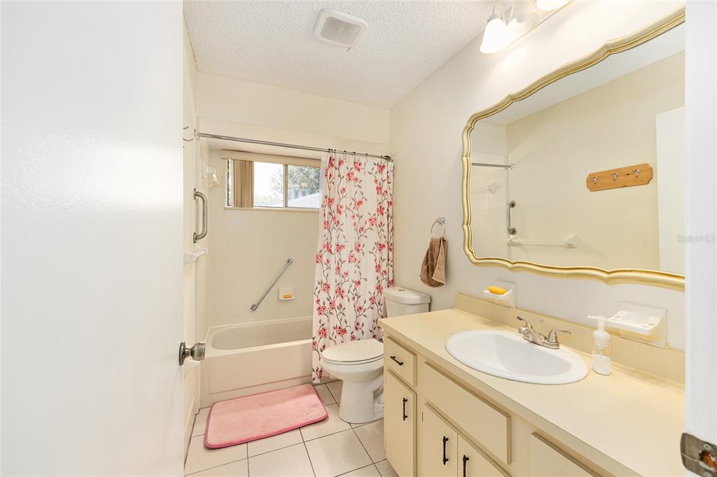10888 Southwest 90th Court Ocala, FL 34481 - Photo 23 of 37 a bathroom with a sink a toilet and shower curtain