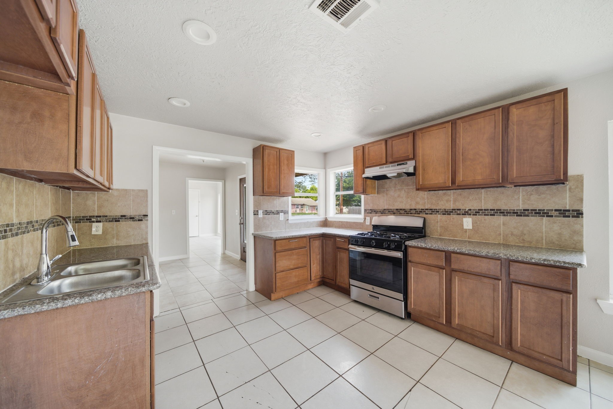 1102 Johnson Street Pasadena, TX 77506 - Photo 3 of 15 a kitchen with stainless steel appliances granite countertop a stove top oven a sink a counter top space and cabinets