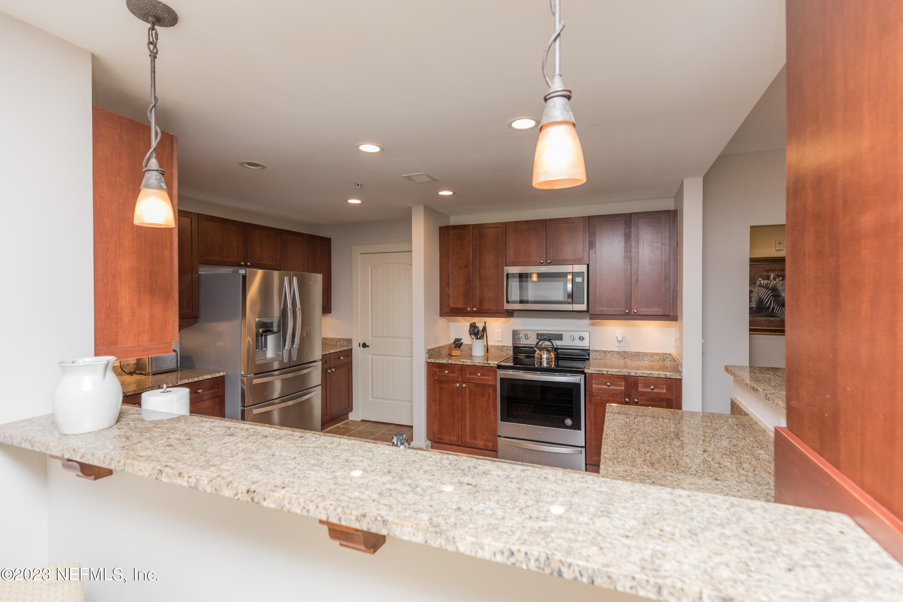 945 Registry Boulevard, Unit 201 St. Augustine, FL 32092 - Photo 42 of 65 a kitchen with stainless steel appliances granite countertop a sink refrigerator and cabinets