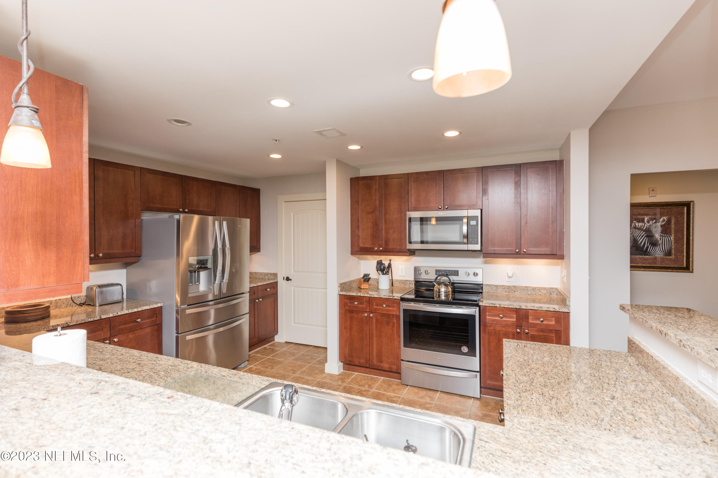945 Registry Boulevard, Unit 201 St. Augustine, FL 32092 - Photo 43 of 65 a kitchen with stainless steel appliances granite countertop a sink stove and refrigerator