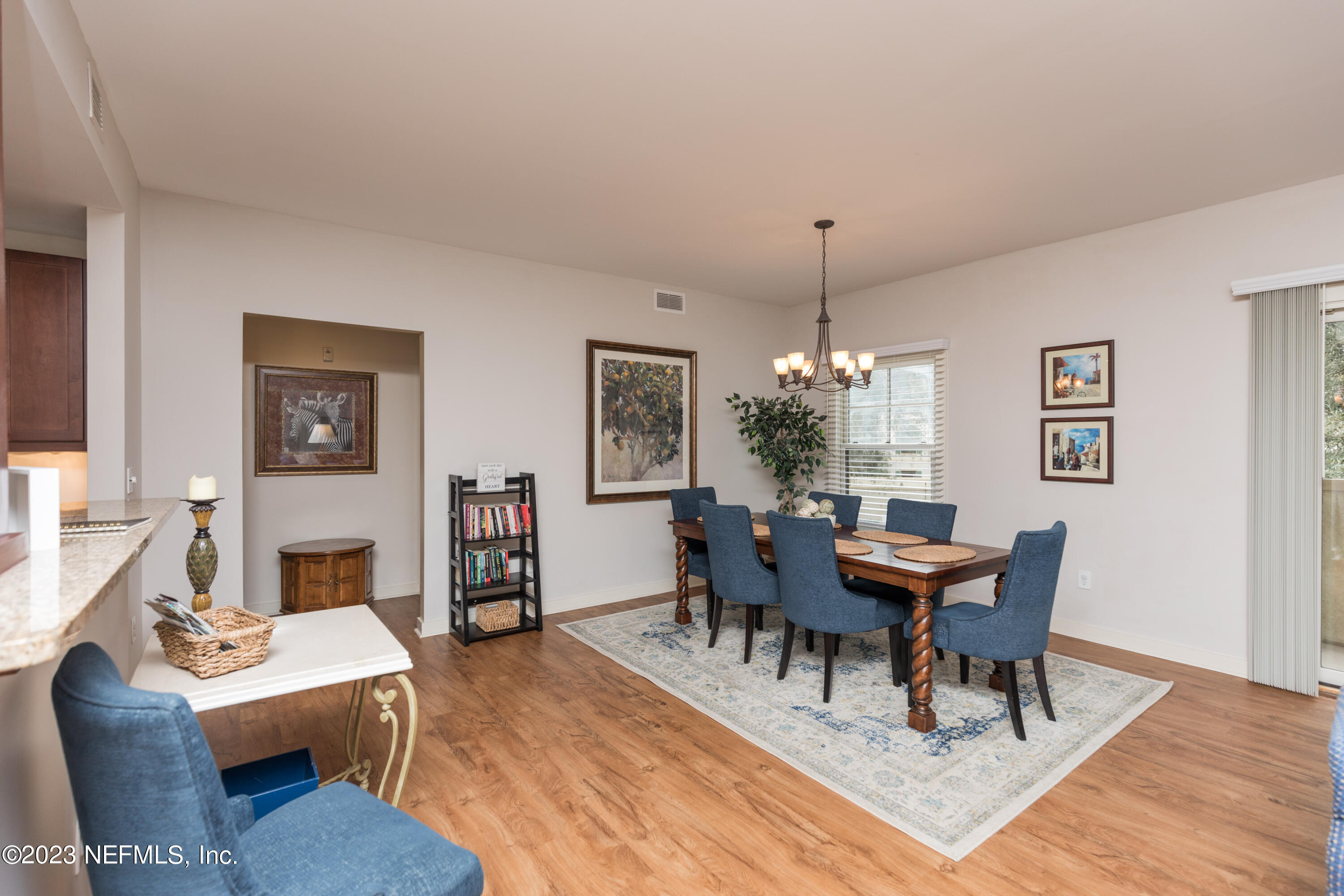 945 Registry Boulevard, Unit 201 St. Augustine, FL 32092 - Photo 52 of 65 a dining room with wooden floor a chandelier a wooden table and chairs