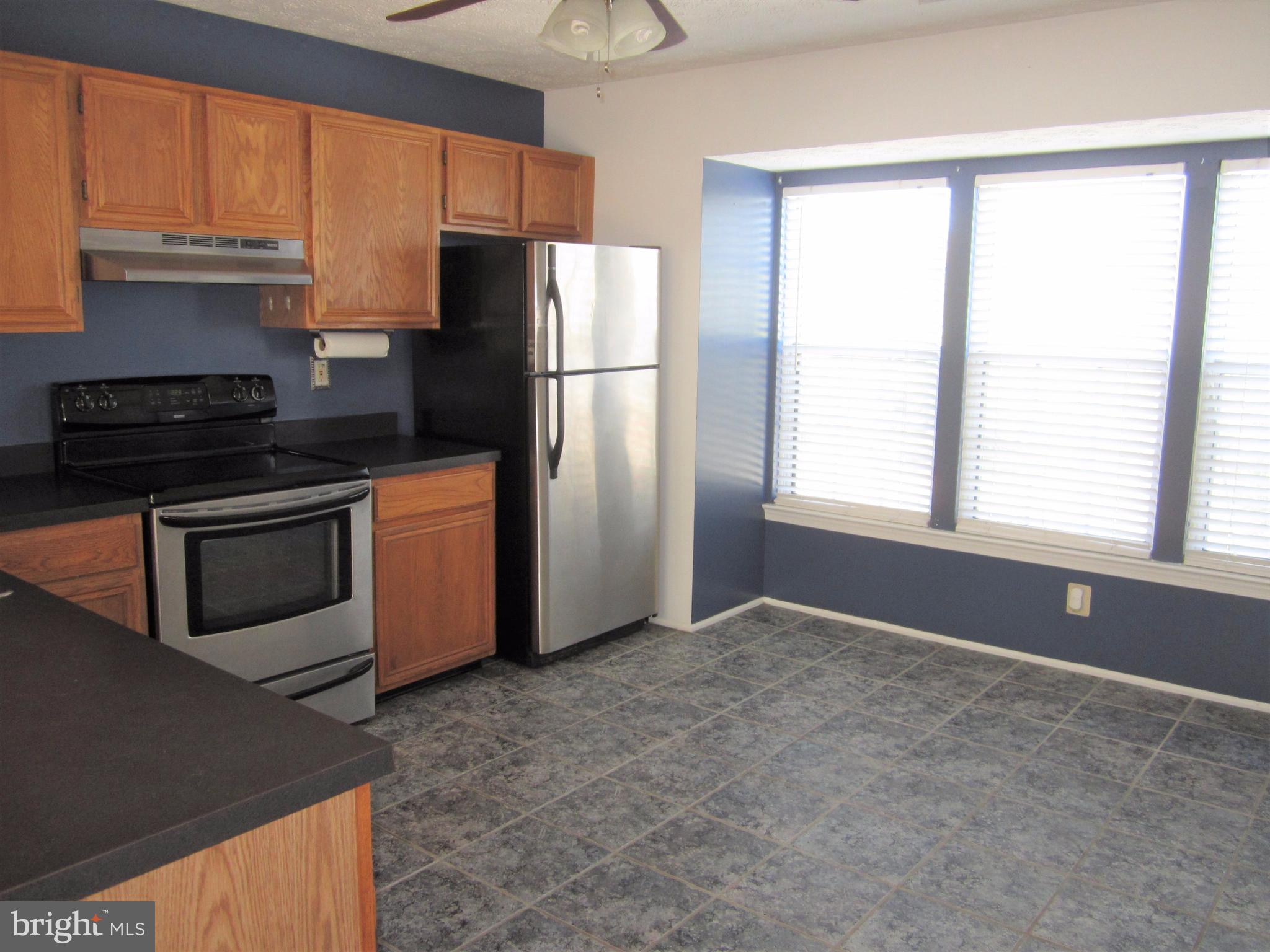 17 Bridle Lane, Unit 72 Baltimore, MD 21236 - Photo 9 of 22 a kitchen with stainless steel appliances a refrigerator a stove a sink and a window
