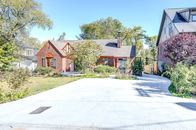front view of house with a yard and potted plants