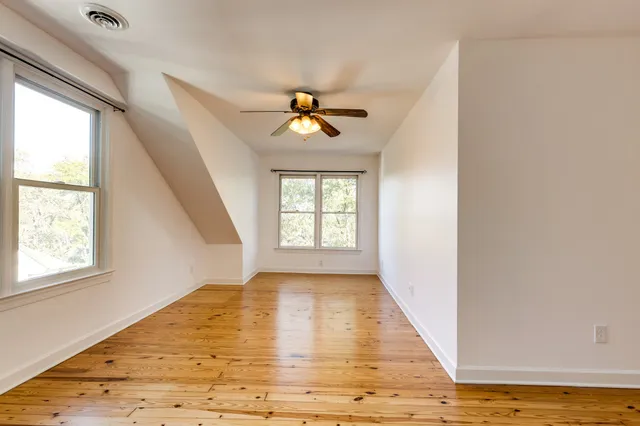 a view of an empty room and window and wooden floor
