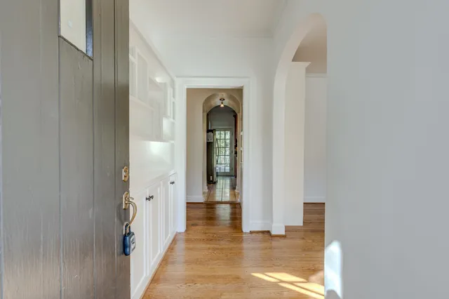 an empty room with fireplace wooden floor and windows