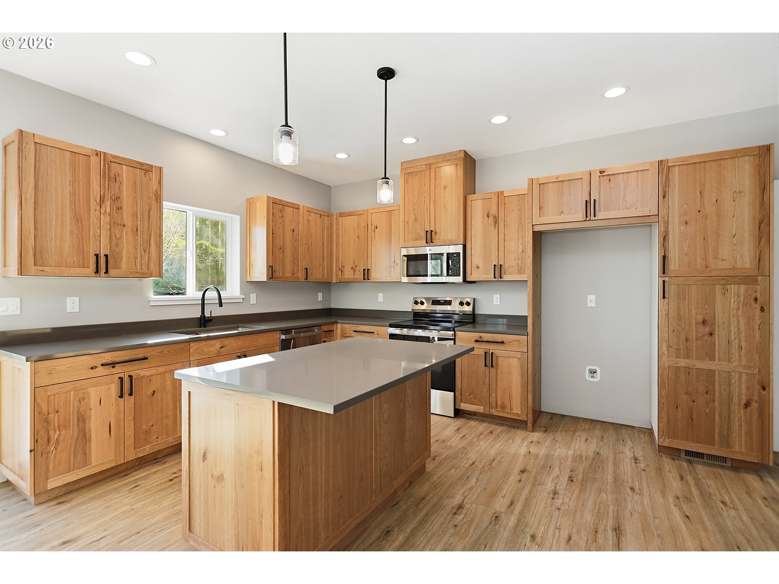 1680 Morton Street The Dalles, OR 97058 - Photo 8 of 36 a kitchen with stainless steel appliances granite countertop a refrigerator a sink dishwasher a stove and white countertops with wooden floor