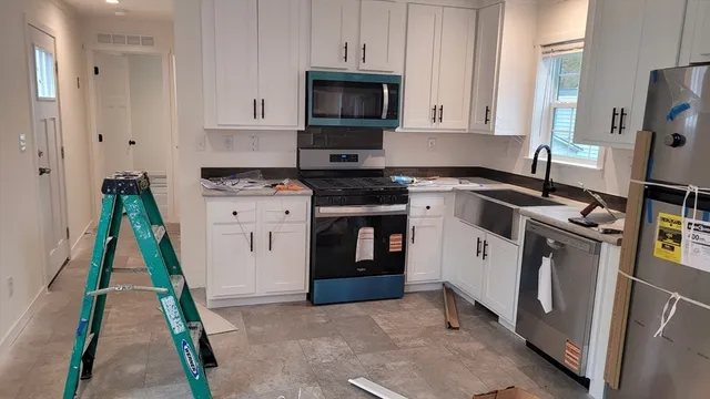 a kitchen with stainless steel appliances granite countertop a stove a sink and a refrigerator