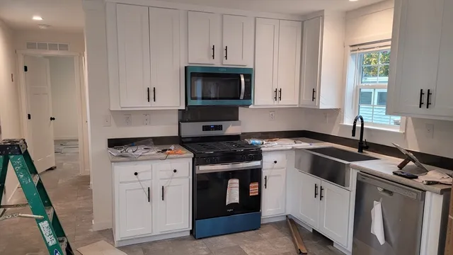 a kitchen with granite countertop a stove sink and cabinets