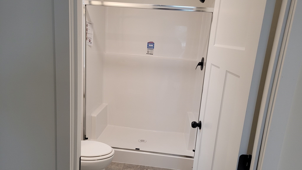 286 Newbury Street, Unit 110 Peabody, MA 01960 - Photo 10 of 15 a bathroom with a shower and a toilet