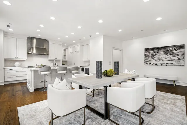 a living room with couches and kitchen view with wooden floor
