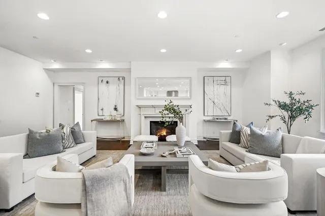 a living room with furniture kitchen view and a large window