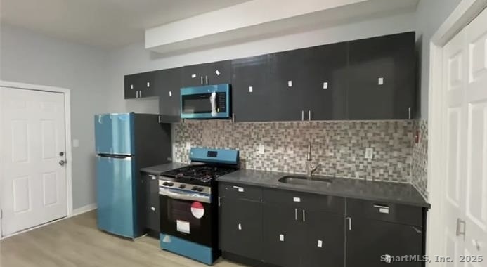 a kitchen with stainless steel appliances granite countertop a refrigerator and a stove