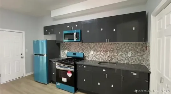 a kitchen with stainless steel appliances granite countertop a refrigerator and a stove