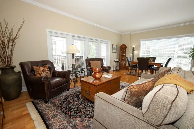 a living room with furniture a chandelier and a dining table with wooden floor