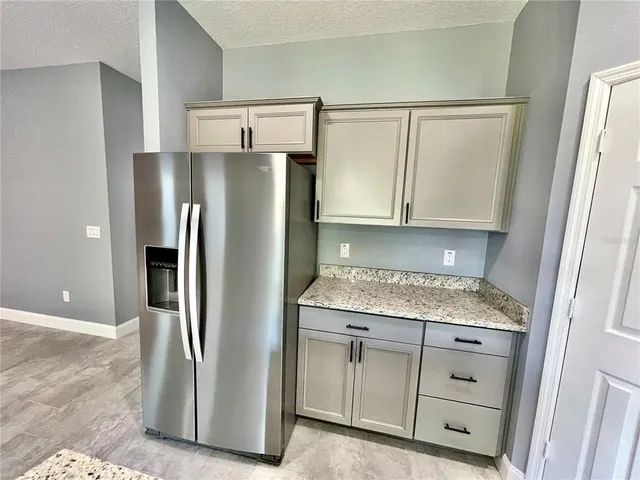 a view of kitchen with stainless steel appliances granite countertop a stove a sink a refrigerator and a counter top space